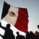 A Mexican supporter waves the national flag at the Zocalo Square in Mexico City June 21, 2006, during the transmission of the FIFA World Cup match between Mexico and Portugal.
ALFREDO ESTRELLA/AFP/Getty Images